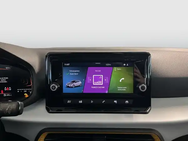 Das Bild zeigt das Innenleben des Fahrzeugs SEAT IBIZA, insbesondere den Touchscreen mit verschiedenen Menüpunkten in einer modernen, schwarzen Ausführung.