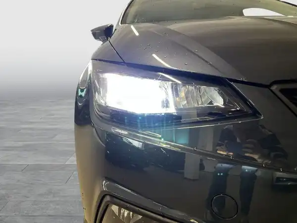 Dieses Bild zeigt die Front eines schwarzen SEAT IBIZA mit eingeschaltetem Scheinwerfer.