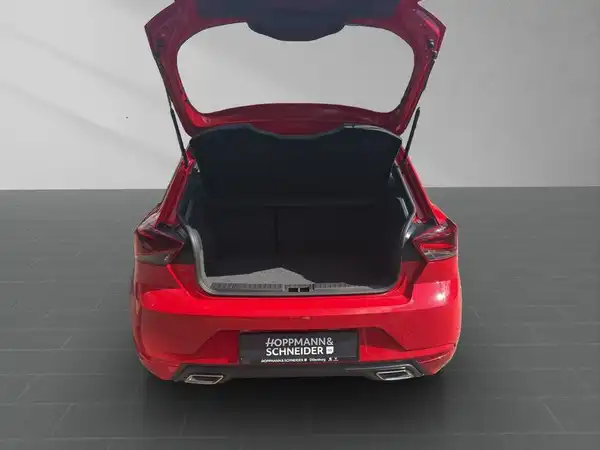 Das Bild zeigt die Rückansicht eines roten SEAT IBIZA mit geöffnetem Kofferraum. Das Händlerlogo von Hoppmann & Schneider ist gut sichtbar.