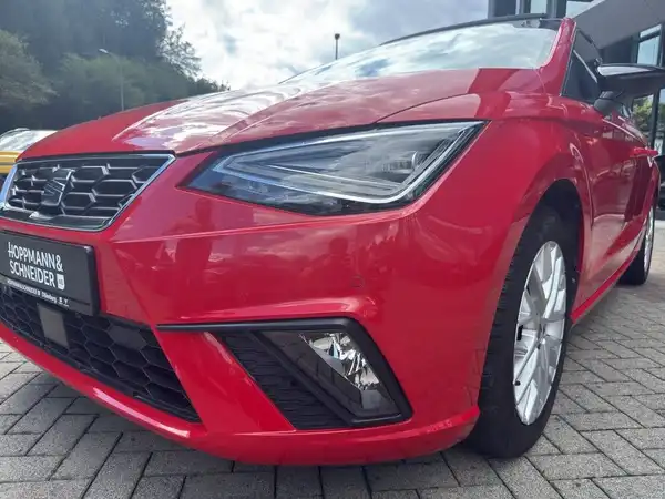 Das Bild zeigt einen roten SEAT IBIZA aus der Frontansicht. Es ist ein Fahrzeugbild, und das Händlerlogo ist sichtbar.