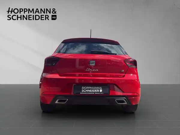 Das Bild zeigt einen roten SEAT IBIZA von hinten. Im Hintergrund ist das Händlerlogo 'HOPPMANN & SCHNEIDER' zu sehen. Es handelt sich um ein Fahrzeugbild.