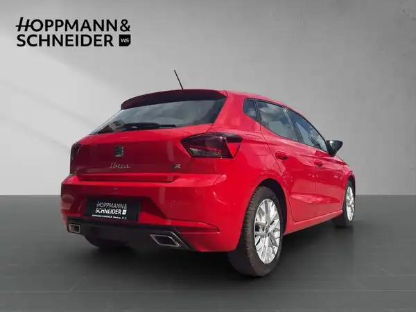 Das Bild zeigt einen roten SEAT Ibiza aus der Rückansicht. Im oberen Bereich ist das Händlerlogo 'HOPPMANN & SCHNEIDER' eingeblendet.
