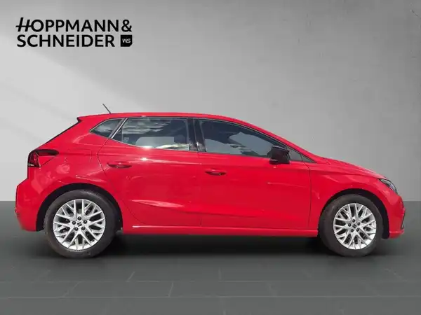Das Bild zeigt einen roten SEAT IBIZA von der Seite. Das Händlermotiv "HOPPMANN & SCHNEIDER" ist im oberen Teil des Bildes sichtbar.