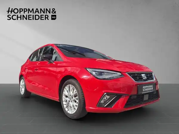 Das Bild zeigt einen roten SEAT IBIZA aus der Seitenansicht mit dem Händlerlogo HOPPMANN & SCHNEIDER im Hintergrund.