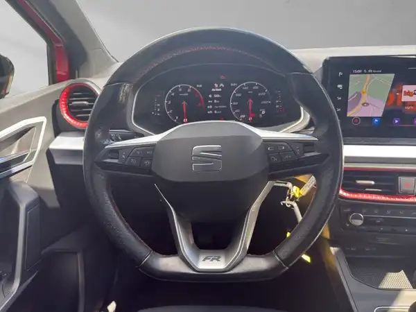 Das Bild zeigt das Innere eines SEAT IBIZA mit einem schwarz gestalteten Armaturenbrett und Lenkrad. Es enthält markante Texteinblendungen.