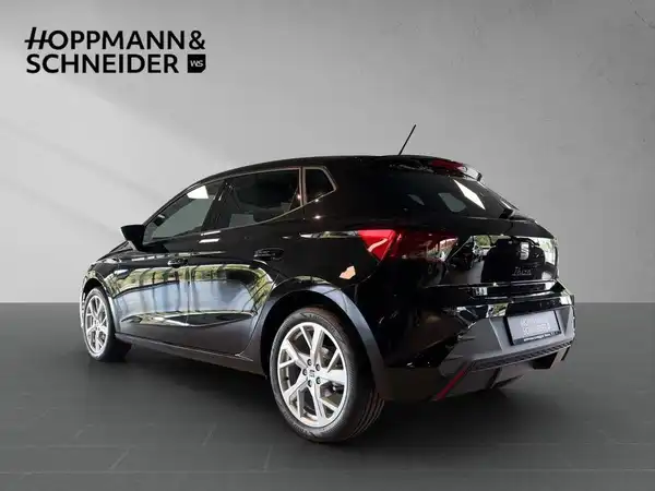 Das Bild zeigt einen schwarzen SEAT IBIZA von der Seite, mit dem Händlerschriftzug "HOPPMANN & SCHNEIDER".