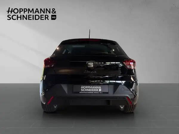 Das Bild zeigt die Rückansicht eines schwarzen SEAT IBIZA. Im Hintergrund ist das Händlerlogo 'HOPPMANN & SCHNEIDER' sichtbar.