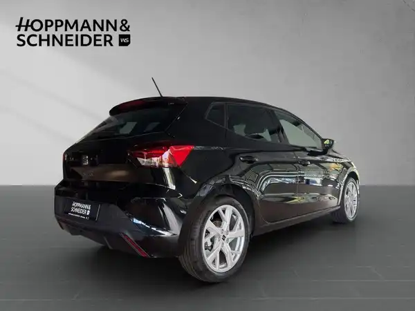 Das Bild zeigt einen SEAT IBIZA von hinten, in schwarzer Farbe, mit dem Händlerlogo von Hoppmann & Schneider im oberen Bereich.