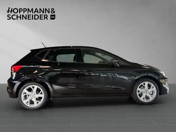 Das Bild zeigt einen schwarzen SEAT IBIZA von der Seite. Das Händlerlogo "HOPPMANN & SCHNEIDER" ist im oberen Bereich des Bildes sichtbar.