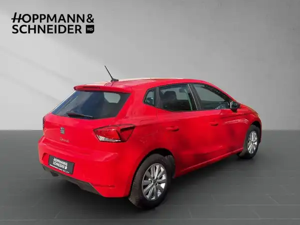 Das Bild zeigt einen roten SEAT IBIZA von der Seite. Im Hintergrund ist das Händlerlogo von HOPPMANN & SCHNEIDER zu sehen.