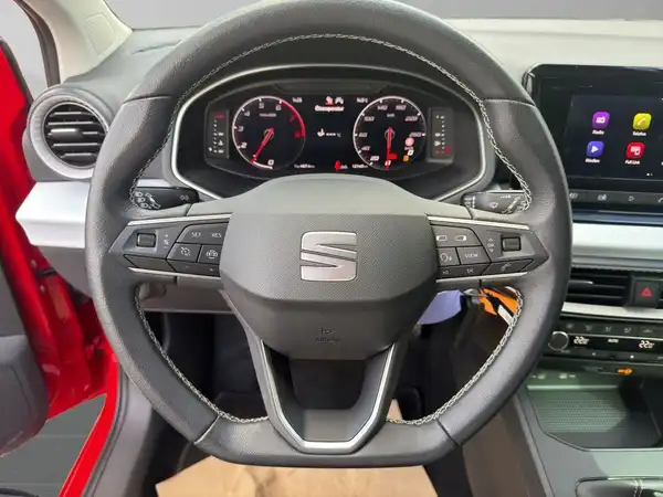 Das Bild zeigt das Innere eines SEAT IBIZA mit einem schwarzen Lenkrad und Armaturenbrett.