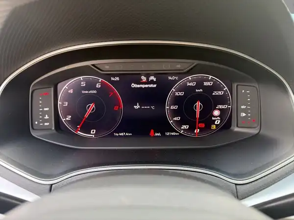 Das Bild zeigt das Armaturenbrett eines Fahrzeugs mit einer digitalen Instrumententafel in Schwarz.