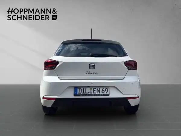 Eine Rückansicht eines weißen SEAT Ibiza mit dem Händlerlogo HOPPMANN & SCHNEIDER im oberen Bereich.