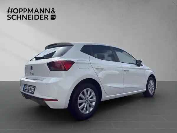 Das Bild zeigt einen weißen SEAT Ibiza, aufgenommen von der Seite. Es ist ein Händlerlogo im Bild integriert.