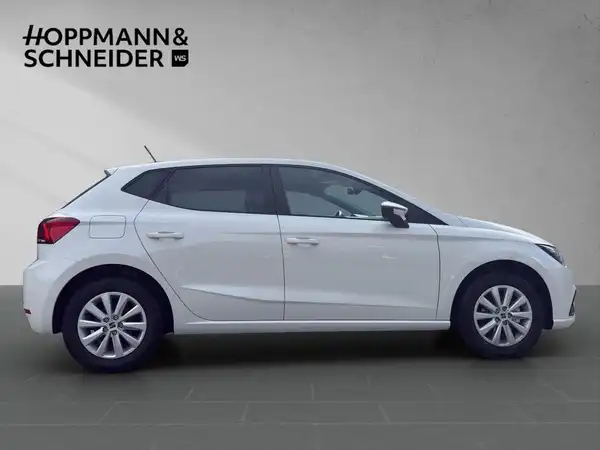 Das Bild zeigt einen weißen SEAT IBIZA von der Seite mit dem Händlerlogo HOPPMANN & SCHNEIDER.