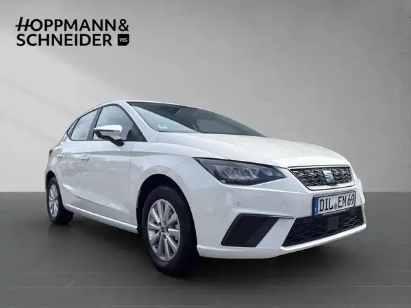 Das Bild zeigt einen weißen SEAT IBIZA von der Seite, mit dem Händlerinformationslogo HOPPMANN & SCHNEIDER im Hintergrund.