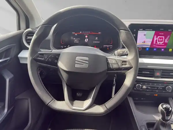 Das Bild zeigt das Innere eines SEAT IBIZA, aufgenommen aus der Sicht des Fahrers. Das Interieur ist schwarz. Es sind markante Texteinblendungen zu sehen.
