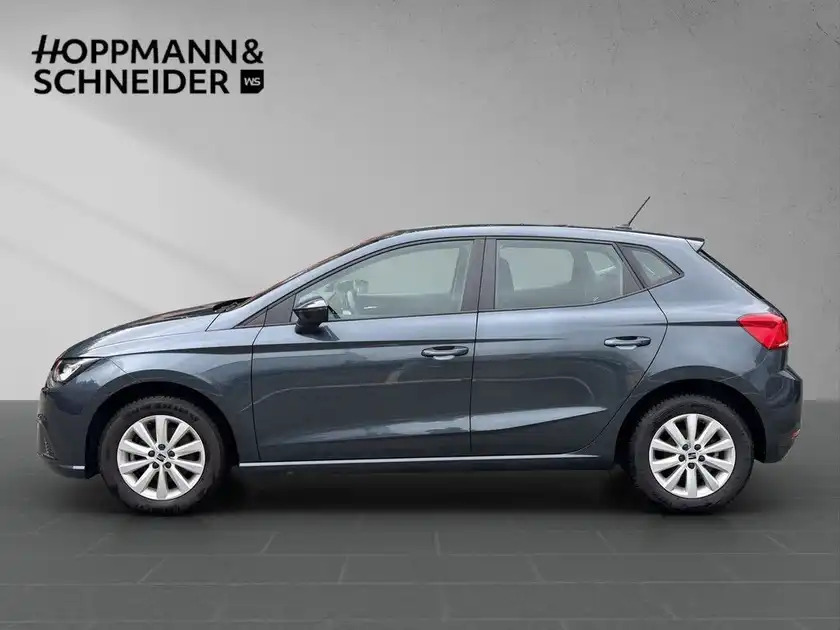 Das Bild zeigt einen grauen SEAT IBIZA von der Seite. Es enthält das Händlerlogo von HOPPMANN & SCHNEIDER.