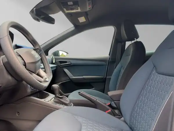 Das Bild zeigt den Innenraum eines SEAT IBIZA mit blauen Sitzen und einer modernen Armaturenbrettgestaltung.