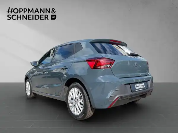 Das Bild zeigt einen grauen SEAT IBIZA von der Seite. Im Hintergrund ist das Händlerlogo 'HOPPMANN & SCHNEIDER' sichtbar.