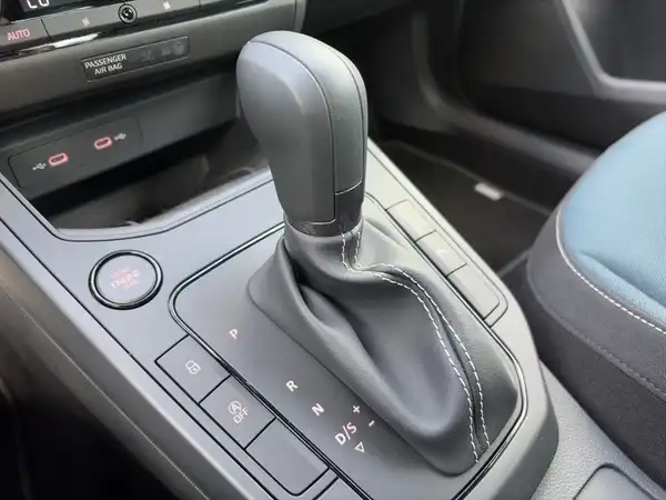 Das Bild zeigt den Schaltknüppel und Teil des Armaturenbretts eines SEAT IBIZA. Das Interieur hat eine schwarze Farbe mit blauen Akzenten.