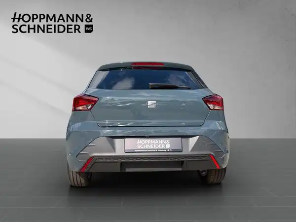 Das Bild zeigt den SEAT Ibiza von hinten in grauer Farbe, mit gut sichtbaren Händlerlogo von HOPPMANN & SCHNEIDER.