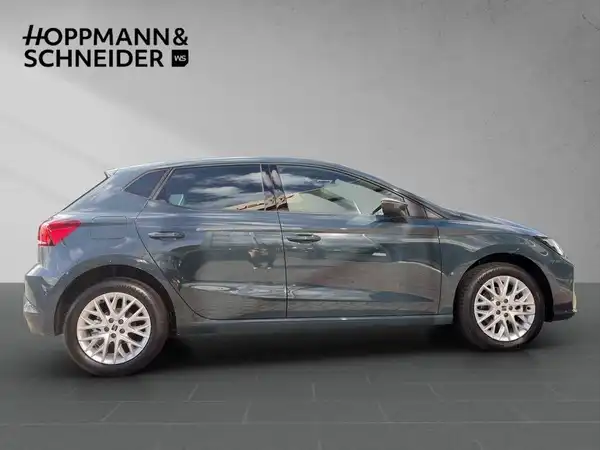 Das Bild zeigt einen grauen SEAT IBIZA von der Seite. Im oberen Bereich ist das Händlerlogo HOPPMANN & SCHNEIDER zu sehen.