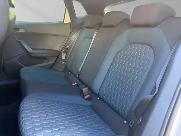Das Bild zeigt den Innenraum eines Fahrzeugs, speziell die Rücksitzbank. Die Sitze sind blau, mit einem strukturierten Design.