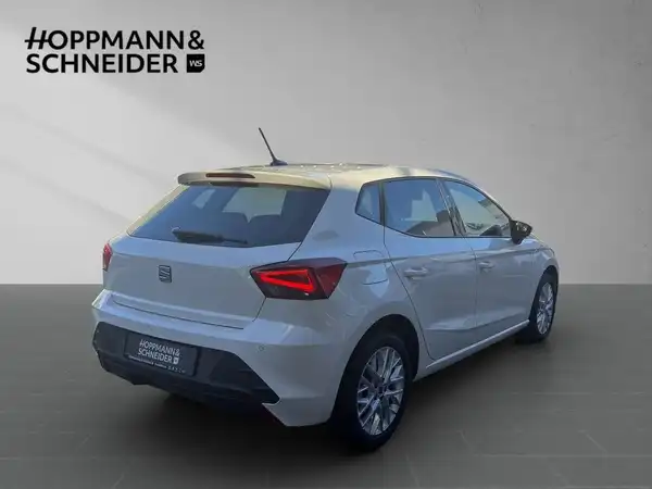 Das Bild zeigt einen weißen SEAT IBIZA von hinten aufgenommen, mit dem Händlerlogo HOPPMANN & SCHNEIDER im oberen Bereich.