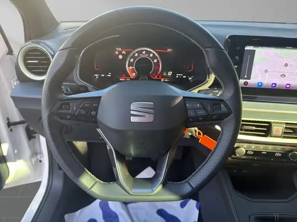 Das Bild zeigt das Innere eines SEAT IBIZA mit einem schwarzen Interieur und dem Blick auf das Lenkrad und das Armaturenbrett.