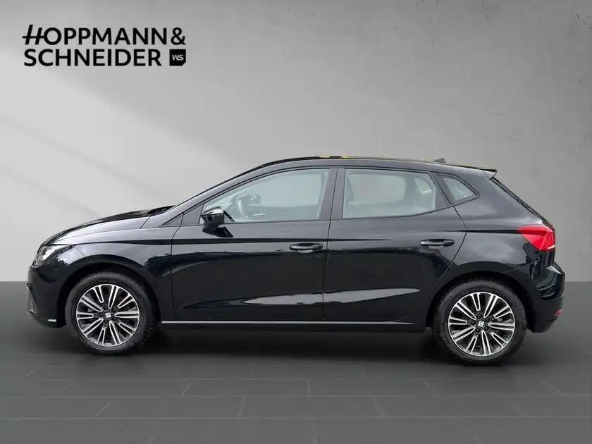 Das Bild zeigt einen SEAT IBIZA von der Seite in schwarzer Farbe. Das Handlungslogo "HOPPMANN & SCHNEIDER" ist sichtbar.