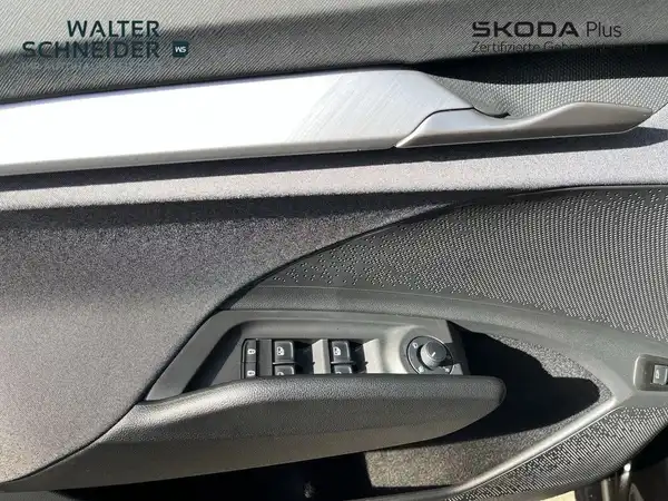 Das Bild zeigt die Türverkleidung des ŠKODA ENYAQ iV. Die Innenfarbe ist schwarz. Es sind Händlerlogos und markante Texteinblendungen zu sehen.