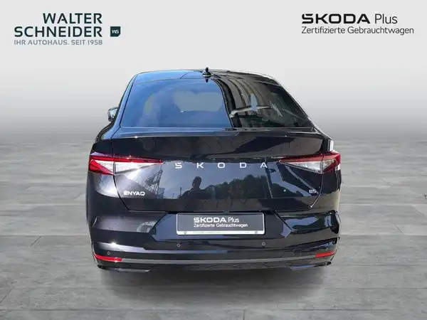 Das Bild zeigt die Rückansicht eines schwarzen ŠKODA ENYAQ iV. Im Hintergrund ist das Händlerlogo von Walter Schneider zu sehen.
