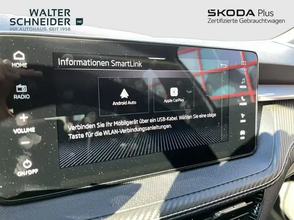 Das Bild zeigt die Innenansicht des Fahrzeugs mit einem Display, das Informationen zu SmartLink anzeigt und mit schwarzem Interieur.