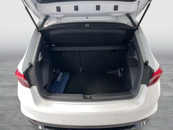 Das Bild zeigt den Kofferraum eines weißen ŠKODA FABIA von hinten. Der Innenraum des Kofferraums ist schwarz.