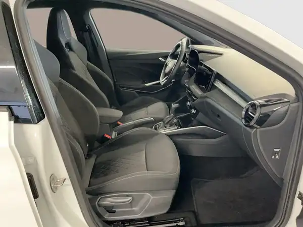 Das Bild zeigt das Inneninterieur eines weißen ŠKODA FABIA mit schwarzen Sitzen und Armaturen.