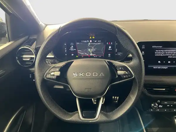 Innenaufnahme des ŠKODA FABIA mit schwarzem Interieur, das Armaturenbrett und das Lenkrad sind gut sichtbar.