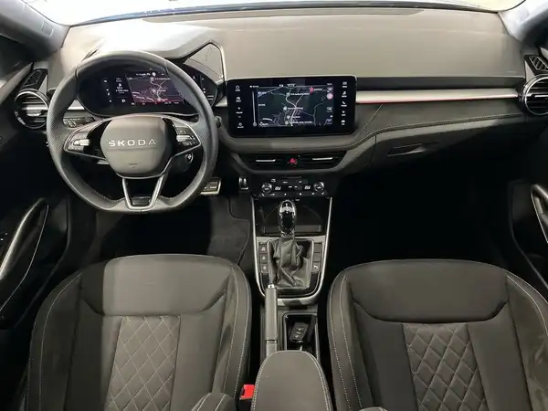 Innenaufnahme eines ŠKODA FABIA mit schwarzen Sitzen und Armaturen.