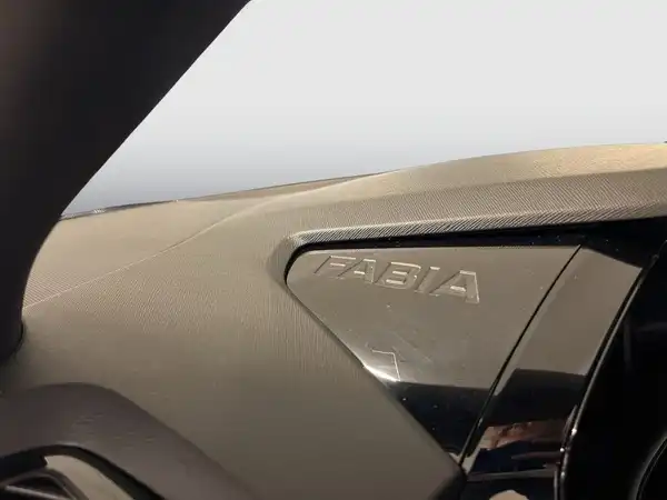 Innenaufnahme des Fahrzeugs ŠKODA FABIA mit schwarzem Interieur und dem eingeprägten Schriftzug 'FABIA'.