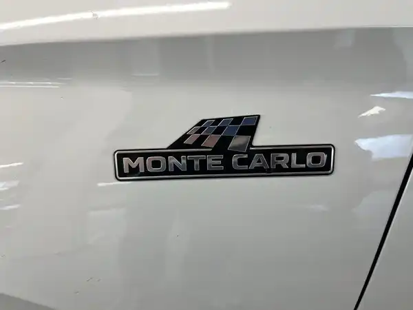 Ein Bild eines Fahrzeugemblems "MONTE CARLO" auf einem weißen Fahrzeug.