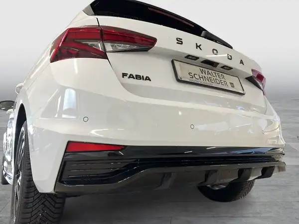 Das Bild zeigt einen weißen ŠKODA FABIA von hinten, mit sichtbarem Händlerschild.