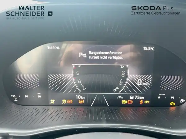 Innenaufnahme des Fahrzeugs, Bildschirm zeigt Informationen an. Das Interieur ist schwarz. Händlerlogo ist vorhanden und es gibt markante Texteinblendungen.