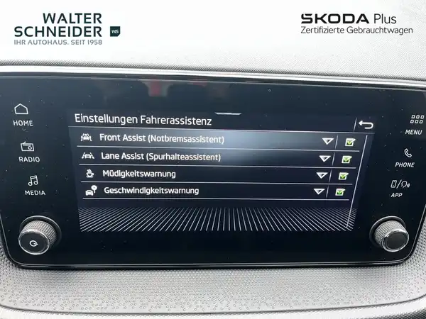 Die Innenaufnahme zeigt das Infotainmentsystem eines ŠKODA. Die Menüansicht mit den Einstellungen für den Fahrerassistenten ist sichtbar, auf dem Bildschirm sind mehrere Optionen aufgelistet. Im oberen Bereich ist das Händlerlogo von Walter Schneider zu sehen.