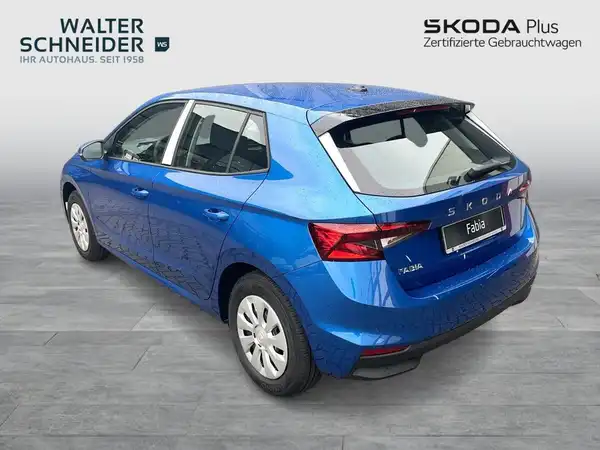 Das Bild zeigt einen blauen ŠKODA FABIA aus der Seitenansicht, versehen mit einem Händlernlogo und zusätzlichen Texteinblendungen.