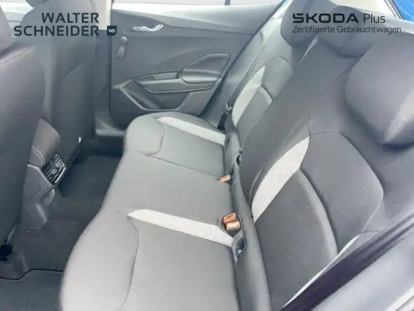 Das Foto zeigt den Innenraum eines ŠKODA FABIAs von der Rücksitzreihe, die Polsterung ist schwarz.