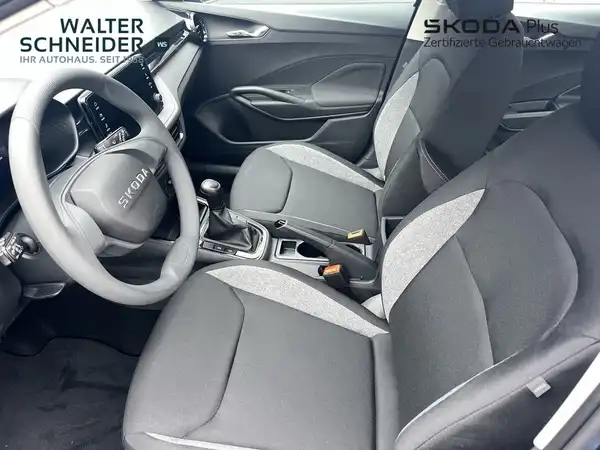 Innenaufnahme des ŠKODA FABIAs mit schwarzem Interieur und grauen Akzenten. Händlerlogo 'WALTER SCHNEIDER' und 'SKODARIS' sichtbar.
