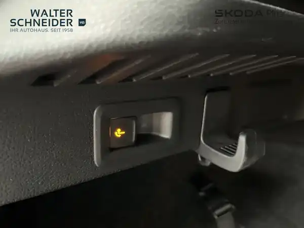 Das Bild zeigt eine Innenaufnahme des ŠKODA KAMIQ mit einem schwarzen Interieur. Es enthält das Händlerlogo von Walter Schneider und zeigt einen Schalter im Innenraum.
