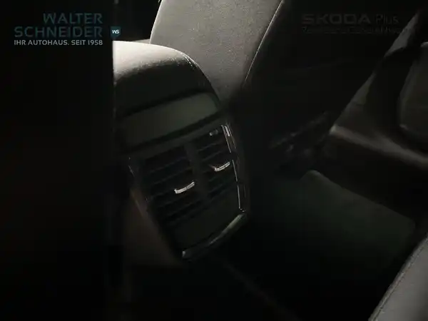 Das Bild zeigt den Innenraum eines Fahrzeugs, aufgenommen aus der Innenansicht. Das Interieur ist schwarz und weist einige markante Texteinblendungen auf, einschließlich des Händlerlogos.