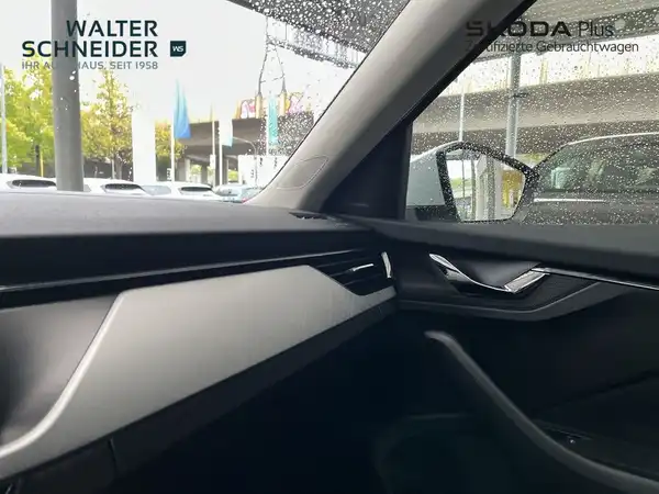 Das Bild zeigt das Innere eines ŠKODA KAMIQ aus einem Innenwinkel mit schwarzem Interieur. Das Händlerlogo ist sichtbar und es gibt markante Texteinblendungen.