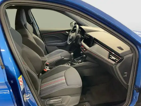 Das Bild zeigt den Innenraum eines blauen ŠKODA KAMIQ. Die Sitze sind schwarz mit grauen Akzenten.